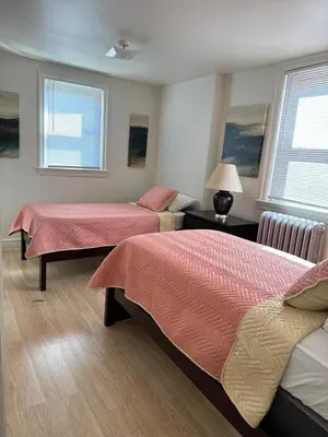a bedroom with two beds with pink and yellow sheets at Beautiful House for Rent in Philadelphia