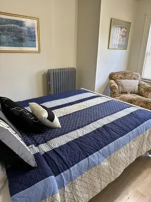 a bedroom with a blue and white bed and a chair at Beautiful House for Rent in Philadelphia