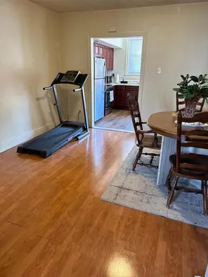 a room with a treadmill and a table and a kitchen at Beautiful House for Rent in Philadelphia