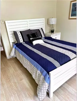 a bedroom with a large bed with blue comforter and pillows at Beautiful House for Rent in Philadelphia