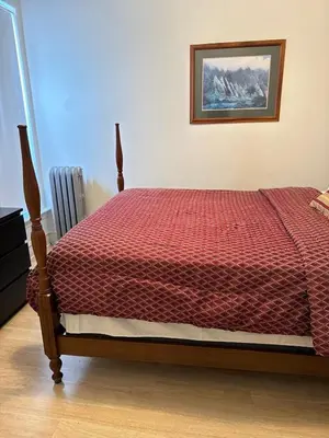 a bedroom with a bed with a red comforter at Beautiful House for Rent in Philadelphia