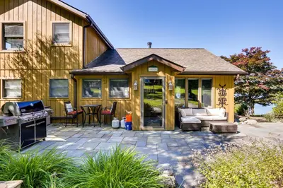 a screened in porch of a house with a grill at Waterfront Home on White Lake Near Bethel Woods! in White Lake