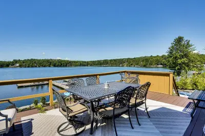 a table and chairs on the deck of a boat at Waterfront Home on White Lake Near Bethel Woods! in White Lake