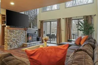 a living room with a couch and a fireplace at Luxurious Poconos Retreat - Hot Tub, Sauna, Games in East Stroudsburg