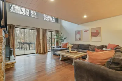 a living room with a couch and a table at Luxurious Poconos Retreat - Hot Tub, Sauna, Games in East Stroudsburg