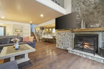 a living room with a fireplace with a tv at Luxurious Poconos Retreat - Hot Tub, Sauna, Games in East Stroudsburg
