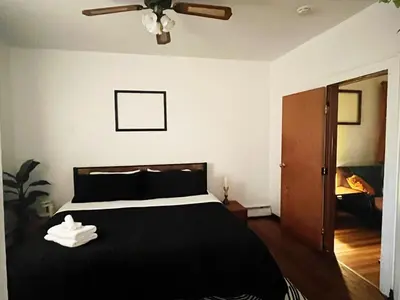 a bedroom with a black bed and a ceiling fan at Ironbound 4 bdrm Industrial Suite! FREE parking in Newark
