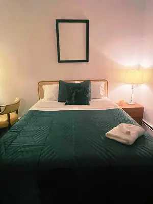 a bedroom with a bed with a green blanket at Ironbound 4 bdrm Industrial Suite! FREE parking in Newark