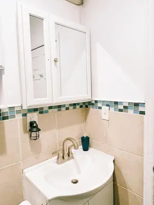 a bathroom with a sink and a cabinet at 3 bdrm stay! Trippy King Suite by Dwtwn Nwk in Newark