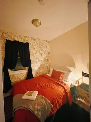 a bedroom with a red bed and a window at 3 bdrm stay! Trippy King Suite by Dwtwn Nwk in Newark