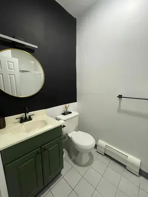 a bathroom with a toilet and a sink and a mirror at 3br 3bath Duplex NY 23 mins in Hoboken