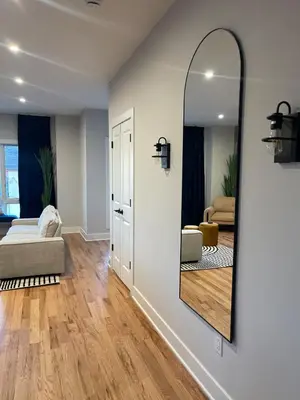 a living room with a large mirror on the wall at 4br 5ba 4 Car Parking Bonus Rm and Back Yard in East Newark