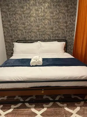 a bed with a pair of shoes sitting on it at 4br 5ba 4 Car Parking Bonus Rm and Back Yard in East Newark