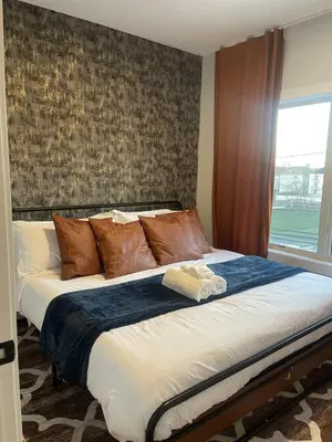 a large bed in a room with a window at 4br 5ba 4 Car Parking Bonus Rm and Back Yard in East Newark