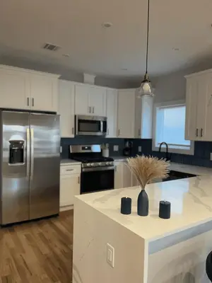a kitchen with a stainless steel refrigerator and a counter at 4br 5ba 4 Car Parking Bonus Rm and Back Yard in East Newark