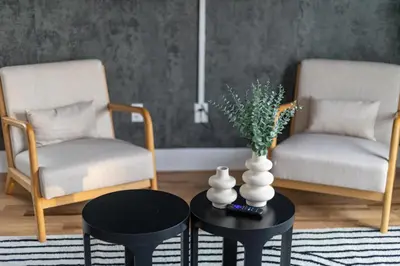 a living room with two chairs and a table with a vase at 2br 3ba 2King bd 3 Car Parking Bonus area with Queen Bed in East Newark