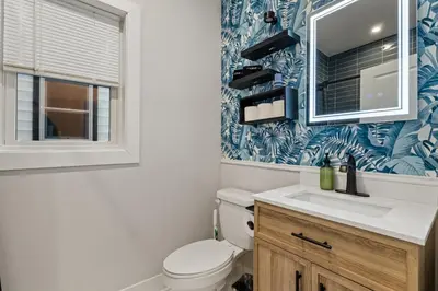 a bathroom with a toilet and a sink and a mirror at 2br 3ba 2King bd 3 Car Parking Bonus area with Queen Bed in East Newark