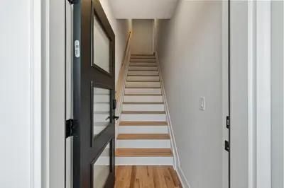 a staircase in a house with white walls and wooden floors at Free Parkng 2br 2ba 2 King beds EWR 15min in East Newark