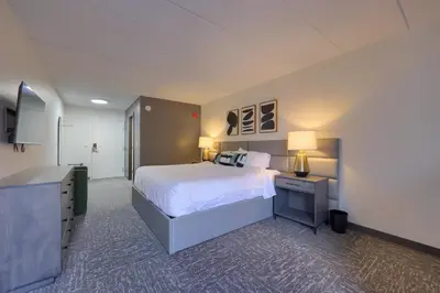 a large bedroom with a bed and a desk with a lamp at Lititz Pointe Inn and Suites in Lititz