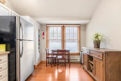 a kitchen with a refrigerator and a table with chairs at Your Gateway to Pocono! in Tannersville