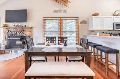 a kitchen and dining room with a table and a fireplace at Your Gateway to Pocono! in Tannersville