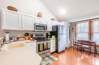 a kitchen with white cabinets and a stainless steel refrigerator at Your Gateway to Pocono! in Tannersville
