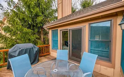 a patio with a table and chairs on a deck at Your Gateway to Pocono! in Tannersville
