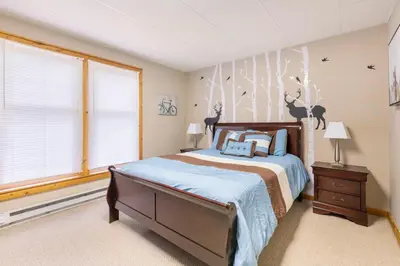 a bedroom with a bed and a wall with deer on it at Your Gateway to Pocono! in Tannersville