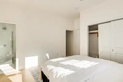 a white bedroom with a bed and a window at 1 Mi to Prudential Center Remote Work-Ready Apt in Newark