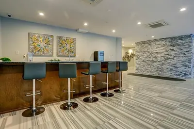 a lobby with a bar with stools and a stone wall at XL Studio - Metro Studio, Chic Stay in Philadelphia