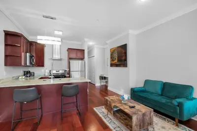 a living room with a green couch and a table at XL Studio - Metro Studio, Chic Stay in Philadelphia