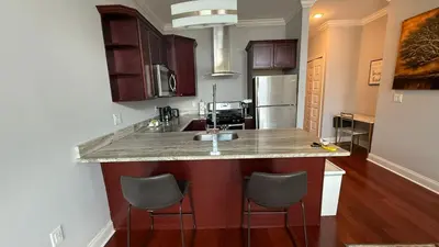 a kitchen with a sink and two bar stools at XL Studio - Metro Studio, Chic Stay in Philadelphia