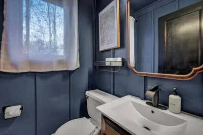 a bathroom with a sink and a toilet and a mirror at Lakefront Movie Theater, Hot Tub, Arcade, Boats in Gouldsboro