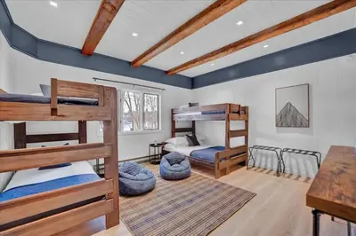 a bedroom with two bunk beds and a desk at Lakefront Movie Theater, Hot Tub, Arcade, Boats in Gouldsboro