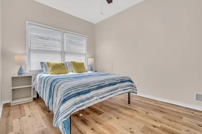 a white bedroom with a bed with two yellow pillows at Bayview Coastal Home - Steps to Shore & Free Parking in Keansburg