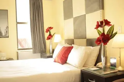 a bedroom with a bed with red flowers on a table at 414 Hotel in New York