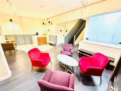 a waiting room with red chairs and a piano at 414 Hotel in New York