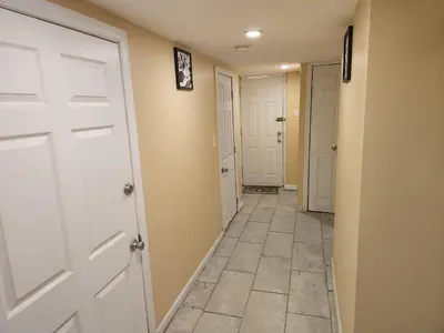 a hallway with a white door and a tile floor at 2kings Apartment in Newark