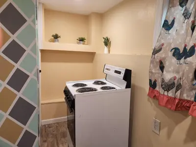 a small kitchen with a stove and a refrigerator at 2kings Apartment in Newark