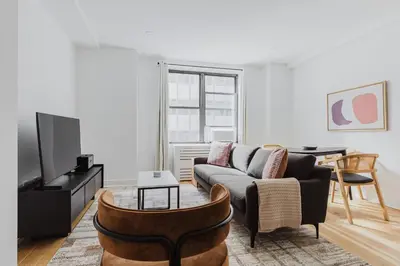 a living room with a couch and a table at Blueground Midtown gym AC nr Chrysler NYC-1665 in New York