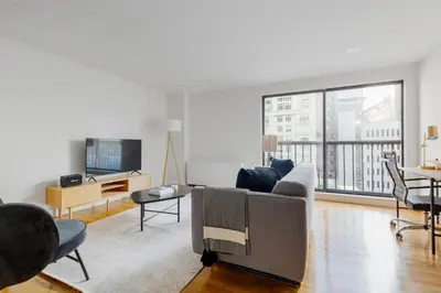 a living room with a couch and a large window at Midtown East 1br w elevator nr transport NYC-1249 in New York