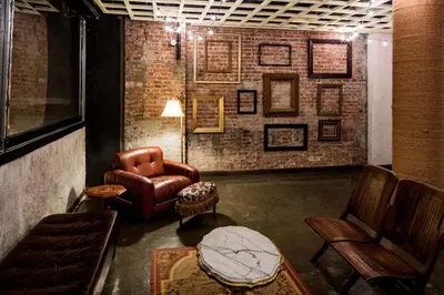 a living room with a leather chair and a table at Orchard Street Hotel in New York