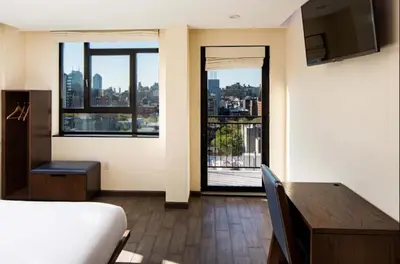 a hotel room with a bed and a desk and window at Orchard Street Hotel in New York