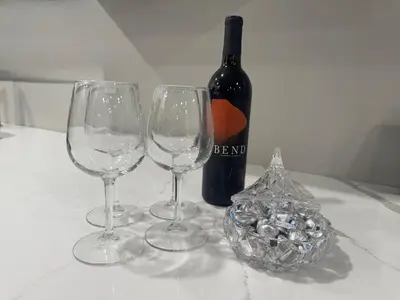three wine glasses sitting on a table with a bottle of wine at Near New York-EWR-JG Mall-Train - Elizabeth NJ in Elizabeth