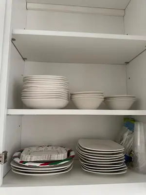 a white cabinet filled with plates and bowls at Near New York-EWR-JG Mall-Train - Elizabeth NJ in Elizabeth