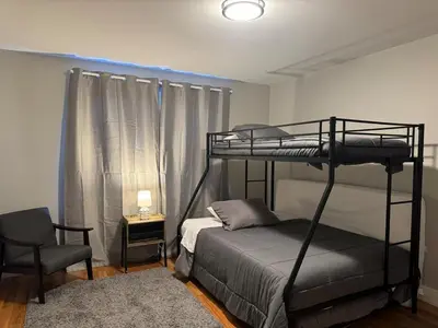 a bedroom with a bunk bed and a chair at Near New York-EWR-JG Mall-Train - Elizabeth NJ in Elizabeth