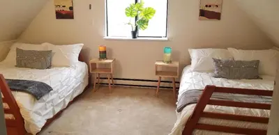 two beds in a room with a window and two tables at Pocono Cabin Fireplace Near Skiing Tubing Parks Shopping Casinos Hot Tub Walk to Lake in Pocono Lake