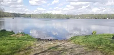 a large lake with a boat in the water at Pocono Cabin Fireplace Near Skiing Tubing Parks Shopping Casinos Hot Tub Walk to Lake in Pocono Lake