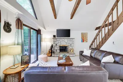 a living room with a leather couch and a fireplace at Pocono Cabin Fireplace Near Skiing Tubing Parks Shopping Casinos Hot Tub Walk to Lake in Pocono Lake