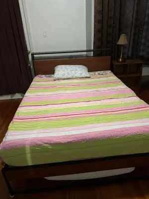 a bed with a striped blanket on top of it at Convenient location near Manhattan easy trip to Times Square in North Bergen